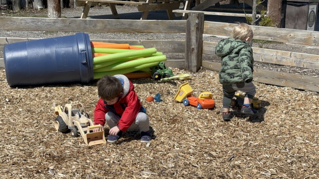 Kids playing in the Heartland Forest fenced play pen
